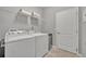 The laundry room features modern washer and dryer units plus convenient shelving for storage at 7834 Minutemen Loop, Winter Garden, FL 34787