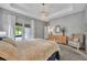 Inviting main bedroom with a chandelier, carpet, tray ceilings and sliding glass doors to the backyard at 7834 Minutemen Loop, Winter Garden, FL 34787