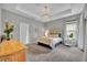 Comfortable main bedroom with tray ceiling, chandelier, carpet and neutral decor at 7834 Minutemen Loop, Winter Garden, FL 34787