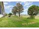 Well-maintained backyard with lawn, trees, and garden featuring a view of the neighborhood at 8865 Se 119Th St, Summerfield, FL 34491