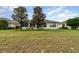 Expansive backyard featuring lawn, trees, screened lanai, and exterior of the single-story home at 8865 Se 119Th St, Summerfield, FL 34491