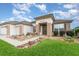 Inviting single-story home showcasing manicured landscaping, a private driveway, and neutral-toned stucco at 8865 Se 119Th St, Summerfield, FL 34491