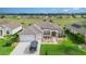 Well-manicured lawn and landscaping complement this inviting home with a neutral color scheme and driveway at 8865 Se 119Th St, Summerfield, FL 34491