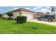 Single-story home featuring lush green lawn, neutral stucco, a two-car garage, and well-maintained landscaping at 8865 Se 119Th St, Summerfield, FL 34491