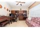 Well-appointed home office with desk, built-in shelving, comfortable seating, and piano at 8865 Se 119Th St, Summerfield, FL 34491