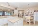 Open-concept kitchen with an island, white cabinetry, breakfast nook and views to the living room at 8865 Se 119Th St, Summerfield, FL 34491