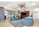 Relaxing living room featuring comfortable blue furniture, a wooden entertainment center with fireplace, and tiled floors at 8865 Se 119Th St, Summerfield, FL 34491