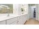 Bright bathroom with double sink vanity, white cabinets, shower with glass doors, and walk-in closet at 8865 Se 119Th St, Summerfield, FL 34491