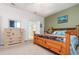 Comfortable main bedroom with decorative wood bed frame, dresser, and en-suite bathroom with glass shower at 8865 Se 119Th St, Summerfield, FL 34491