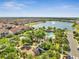 Aerial view showing a pool, playground, lake and residences in a Gathering friendly community with mature landscaping and amenities at 9533 Mere Pkwy, Orlando, FL 32832