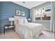 Cozy bedroom with a blue accent wall, plush carpeting, and a large window offering natural light at 9533 Mere Pkwy, Orlando, FL 32832