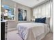Comfortable bedroom featuring a large window with sheer curtains, a cozy bed with plush pillows, and stylish decor at 9533 Mere Pkwy, Orlando, FL 32832