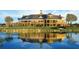 The image shows the clubhouse with a reflective lake in the foreground and an adjacent golf course at 9533 Mere Pkwy, Orlando, FL 32832