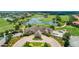 An aerial showcases the clubhouse situated on a golf course featuring water features and meticulous landscaping at 9533 Mere Pkwy, Orlando, FL 32832