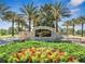 Community sign at Eagle Creek featuring stone architecture, lush landscaping, and vibrant floral arrangements at 9533 Mere Pkwy, Orlando, FL 32832