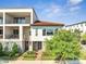 Modern townhome with stucco exterior, red tile roof, balconies, and well-maintained landscaping at 9533 Mere Pkwy, Orlando, FL 32832