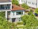 Aerial view of a modern two-story house with a red tile roof, lush greenery, and a well-maintained lawn at 9533 Mere Pkwy, Orlando, FL 32832