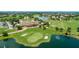Aerial view of the golf course and clubhouse with manicured greens, sand traps and scenic pond at 9533 Mere Pkwy, Orlando, FL 32832