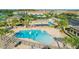 A community pool aerial view showcases lounge chairs and a splash pad surrounded by trees and manicured landscaping at 9533 Mere Pkwy, Orlando, FL 32832