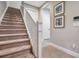 Carpeted staircase with white railing and baseboards, leading to the upper level of the home with wall art at 9533 Mere Pkwy, Orlando, FL 32832