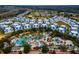 An aerial view of a beautiful resort style community with a waterpark, lush landscaping, and residential housing at 1041 Castle Pines Ct, Reunion, FL 34747