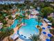 Overhead of a resort-style pool area, featuring water slides, pools, lounge chairs, and shaded cabanas at 1041 Castle Pines Ct, Reunion, FL 34747