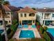 Aerial view of private pool with lounge chairs, lovely landscaping and mediterranean villas at 1041 Castle Pines Ct, Reunion, FL 34747