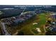 Aerial view showcasing the neighborhood's well-maintained homes adjacent to the lush green fairways of a golf course at 1041 Castle Pines Ct, Reunion, FL 34747