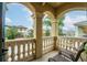 A balcony with stone pillars, a stone railing, and comfortable seating overlooking a quiet residential street at 1041 Castle Pines Ct, Reunion, FL 34747