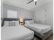 Bright bedroom featuring two beds with plush bedding and stylish decor at 1041 Castle Pines Ct, Reunion, FL 34747