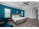 Stylish bedroom featuring a teal accent wall, modern furnishings, and ample natural light at 1041 Castle Pines Ct, Reunion, FL 34747