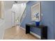 Elegant entryway features staircase, console table with flowers, and blue accent wall at 1041 Castle Pines Ct, Reunion, FL 34747