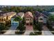 Aerial view of a stunning two-story home with a tile roof, paver driveway, and well-manicured landscaping at 1041 Castle Pines Ct, Reunion, FL 34747