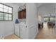 Well-lit laundry room featuring a modern washer and dryer, storage, and an ironing board at 1041 Castle Pines Ct, Reunion, FL 34747