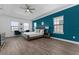 Spacious primary bedroom boasts a tray ceiling, wood floors and blue accent wall at 1041 Castle Pines Ct, Reunion, FL 34747