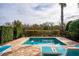 Private in-ground pool with brick surround, nearby lounge chairs, and mature landscaping at 1041 Castle Pines Ct, Reunion, FL 34747