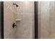 Modern shower with tan tiles, black fixtures, and glass door at 1041 Castle Pines Ct, Reunion, FL 34747