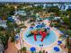 Vibrant waterpark featuring colorful slides, splash pads, and lounge areas surrounded by lush tropical landscaping at 1041 Castle Pines Ct, Reunion, FL 34747