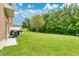 A large, private backyard featuring a lush green lawn, mature trees, and ample space for outdoor enjoyment at 10656 Savannah Plantation Ct, Orlando, FL 32832