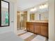 Bathroom featuring a double vanity and a glass enclosed shower with tile surround at 10656 Savannah Plantation Ct, Orlando, FL 32832
