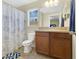 Neutral bathroom featuring a dark vanity, large mirror and shower/tub with a white curtain at 10656 Savannah Plantation Ct, Orlando, FL 32832