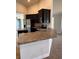 A view of the kitchen with stainless steel appliances, dark cabinets, and a breakfast bar at 107 Athabasca Dr, Poinciana, FL 34759