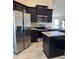 Modern kitchen featuring stainless steel appliances, dark cabinetry and island at 107 Athabasca Dr, Poinciana, FL 34759