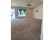 Expansive living room with neutral carpeting, large windows and ceiling fan at 107 Athabasca Dr, Poinciana, FL 34759