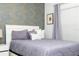 Comfortable Primary bedroom with stylish wallpaper, neutral bedding, and ample natural light at 1070 Splash Shot Pl, Davenport, FL 33896