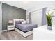 Comfortable bedroom with stylish wallpaper, neutral bedding, and ample natural light at 1070 Splash Shot Pl, Davenport, FL 33896