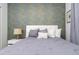 Comfortable bedroom featuring stylish accent wall, nightstand with lamp, and plush bedding at 1070 Splash Shot Pl, Davenport, FL 33896