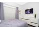 Well-lit bedroom showcasing a modern dresser, TV, and comfortable bedding at 1070 Splash Shot Pl, Davenport, FL 33896