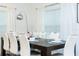 Dining table set for six, with crisp white linens, bright windows and accent lighting at 1070 Splash Shot Pl, Davenport, FL 33896