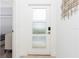 Clean and bright entryway with modern door, decorative artwork, and a glimpse into the bedroom at 1070 Splash Shot Pl, Davenport, FL 33896